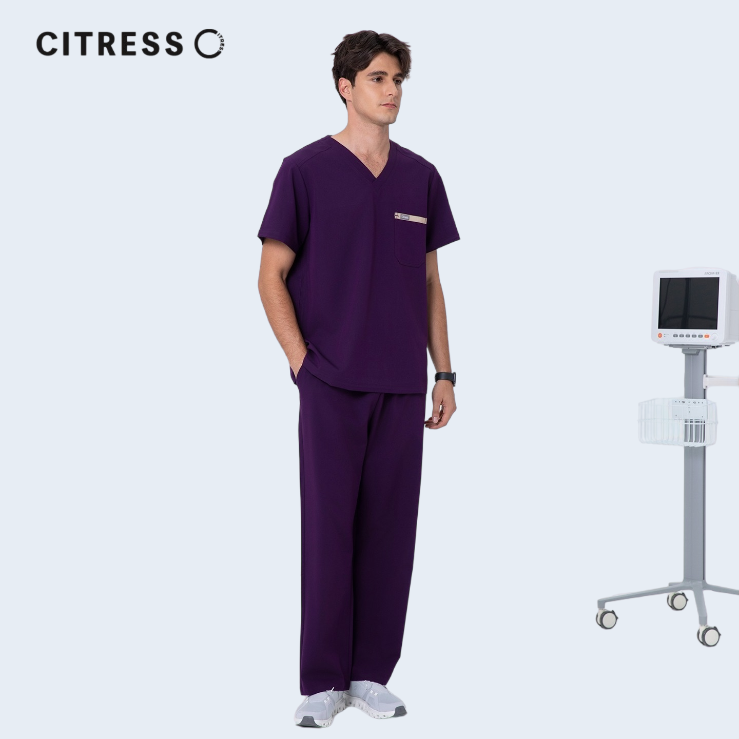 Male doctor wearing CITRESS purple scrub set in hospital, professional medical workwear