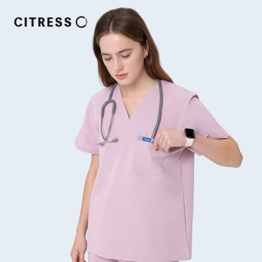 Close-up of CITRESS pink scrub top, showing V-neck and functional pocket